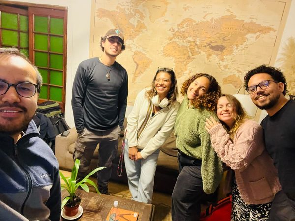 Grupo de huéspedes en el salón común, junto al mapamundi de la pared